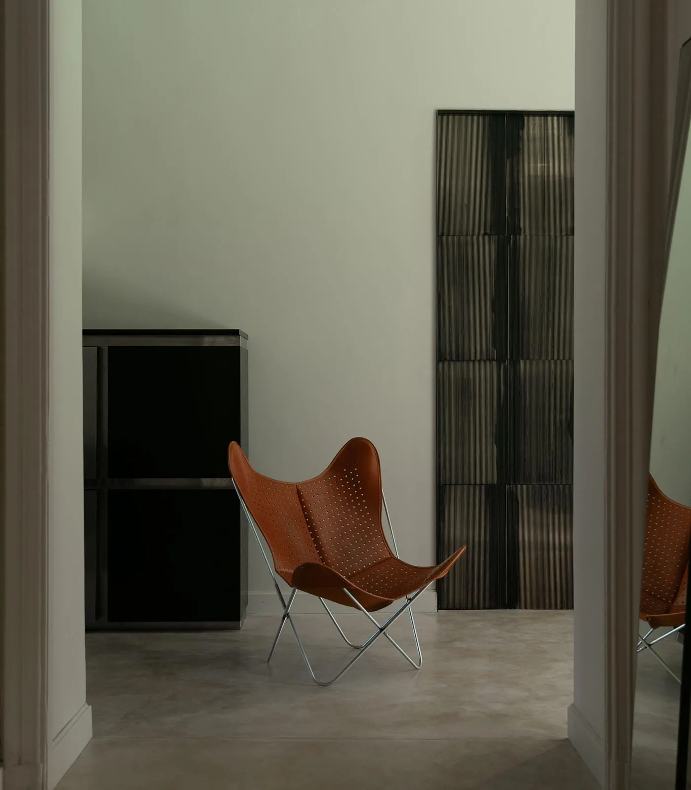 AA Butterfly© armchair in perforated cognac leather with a chrome frame